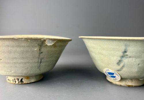 fig 1. A pair of small antique Chinese porcelain bowls with flared rims, raised foot rings, and pale greenish-white glazed finishes displaying subtle surface accretions.