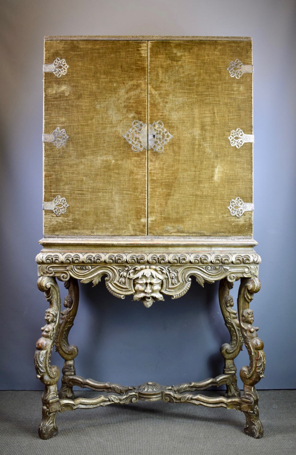 17th century style velvet covered cabinet upon grotesque carved silvered wood stand