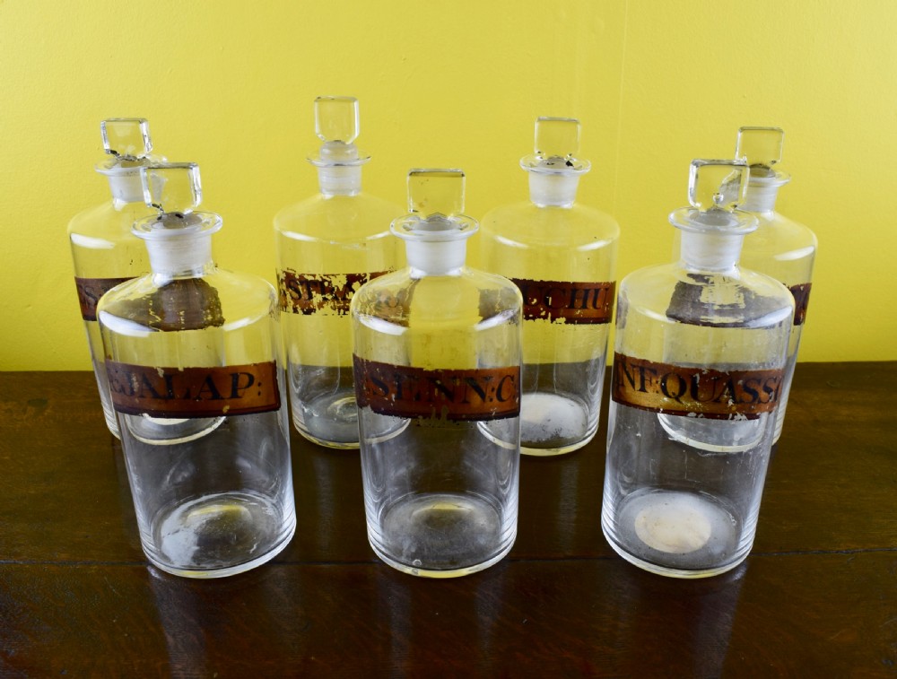 Seven Antique blown glass pharmacy bottles with gilt labels View II