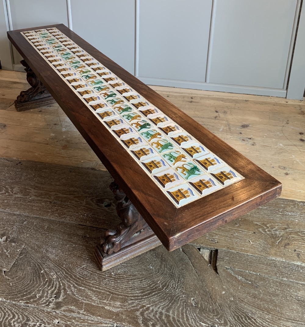 Unusual tile top bench with carved oak griffin supports