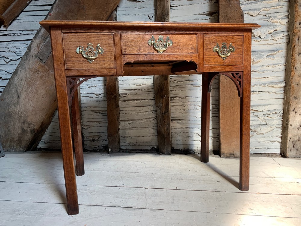 Georgian oak lowboy with three frieze drawers and pierced brass handles View II