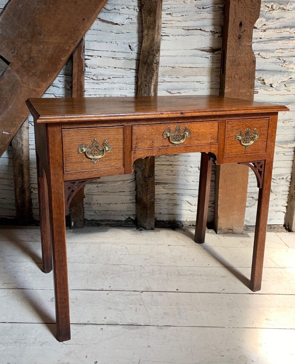 Georgian oak lowboy with three frieze drawers and pierced brass handles View III