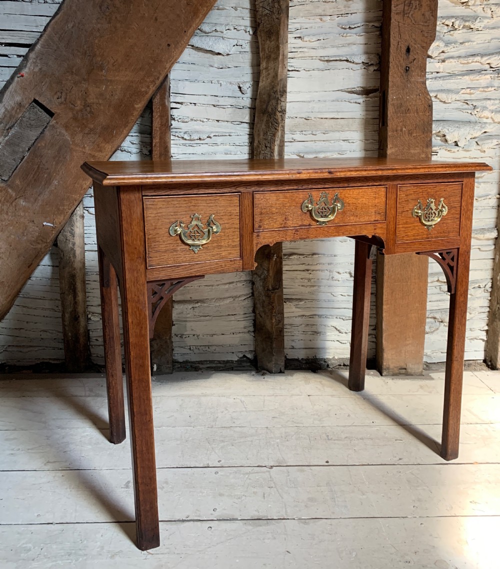 Georgian oak lowboy with three frieze drawers and pierced brass handles View IV