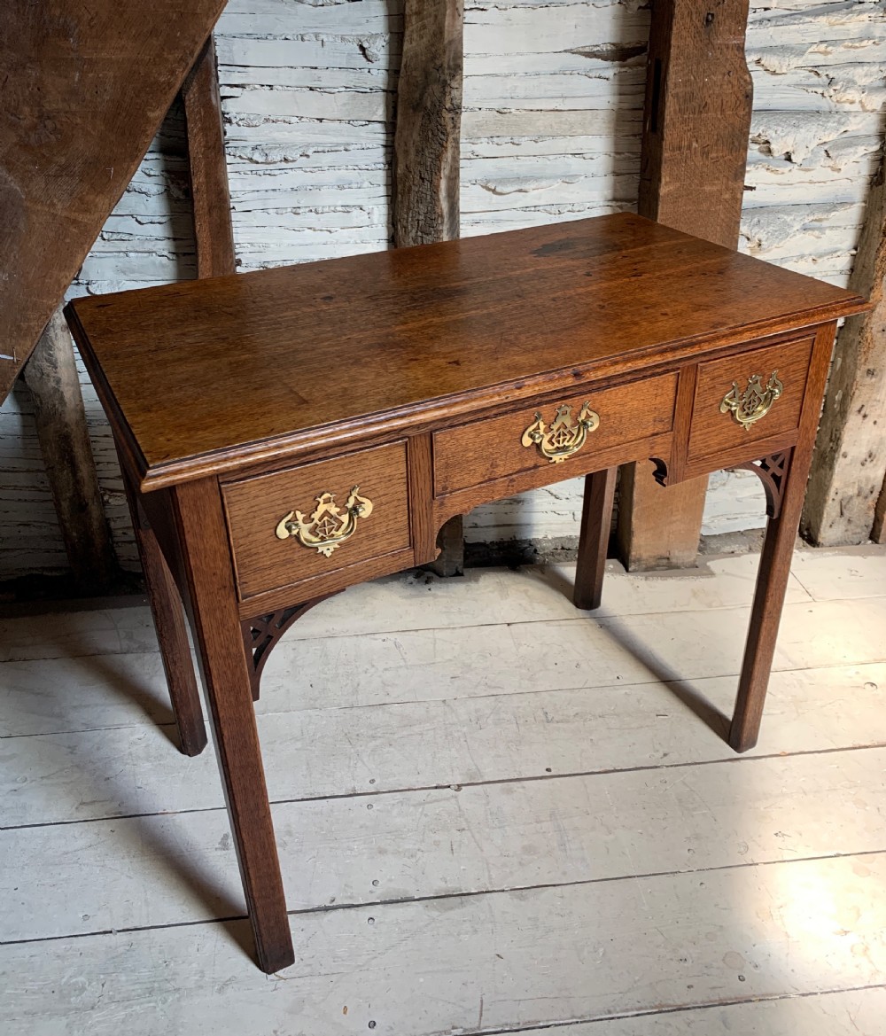 Georgian oak lowboy with three frieze drawers and pierced brass handles View V