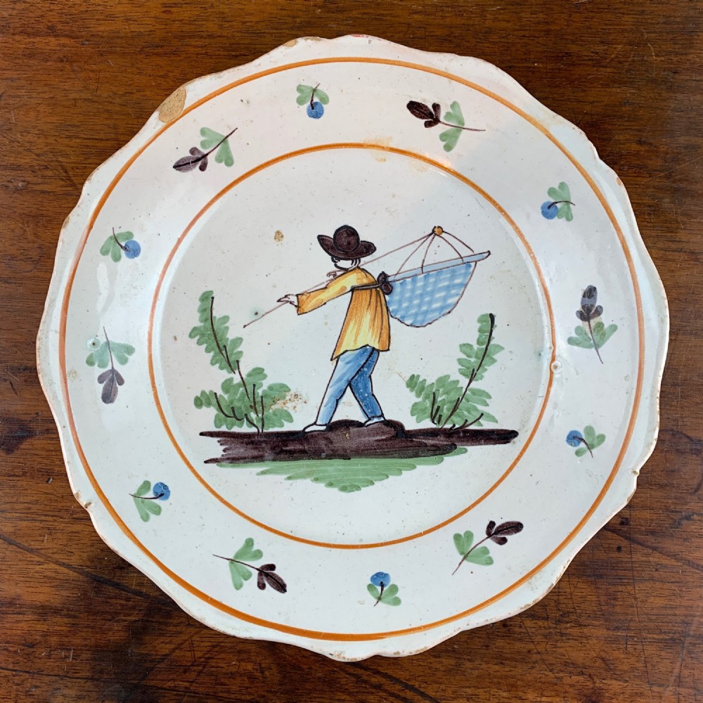 Antique French faience plate painted with a fisherman