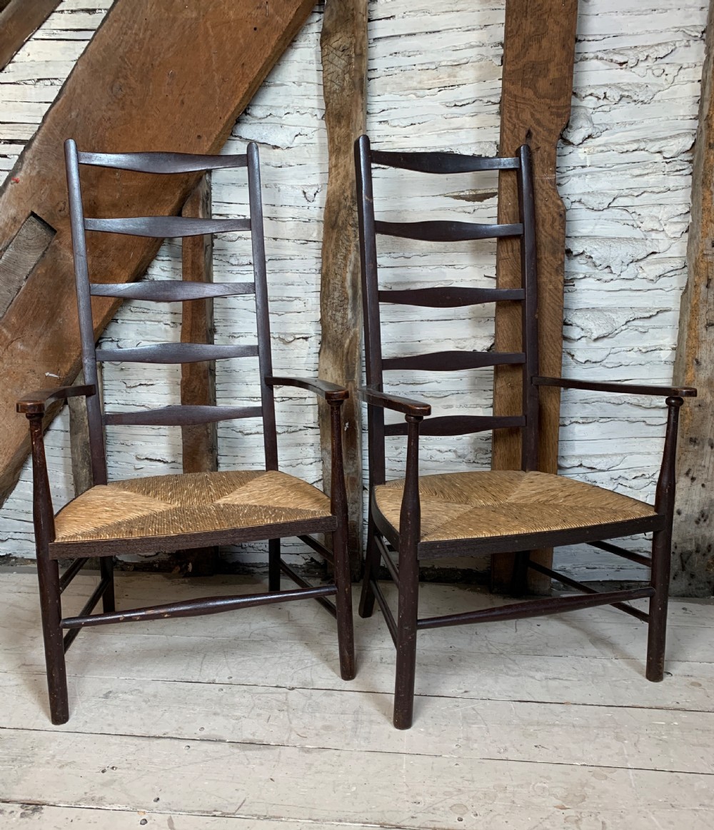 Pair of Arts & Crafts stained beech ladder back chairs with rush seats