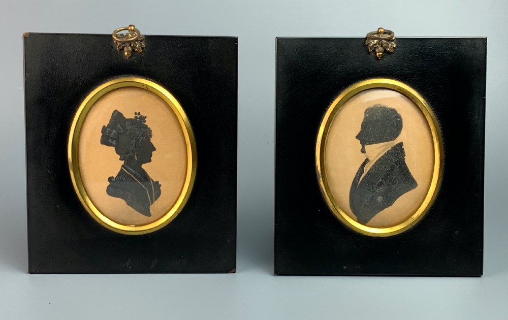 Pair of Regency cut paper silhouettes of a lady and gentleman with painted highlights