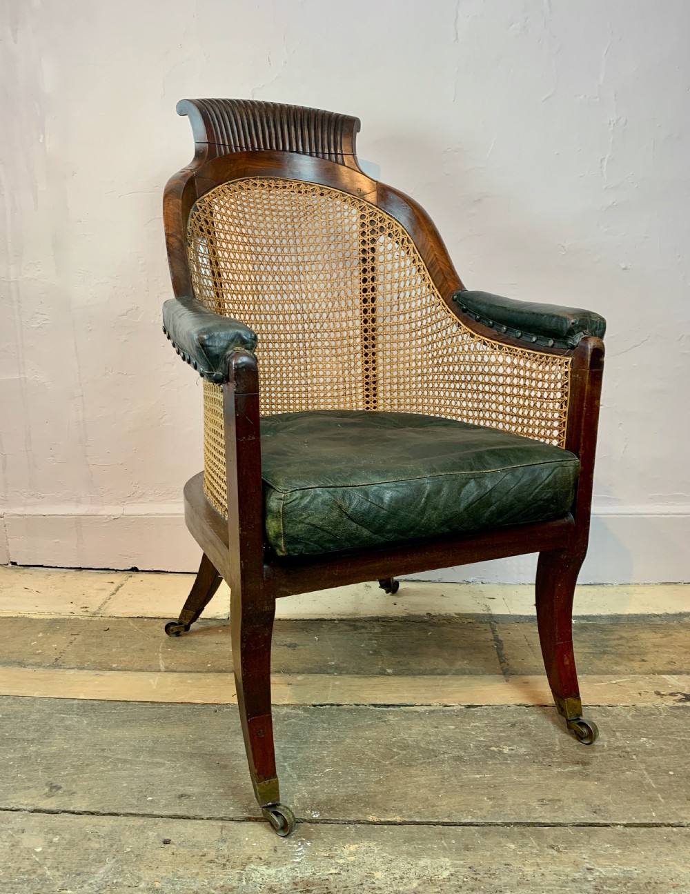Regency mahogany bergere library armchair with loose leather cushion seat