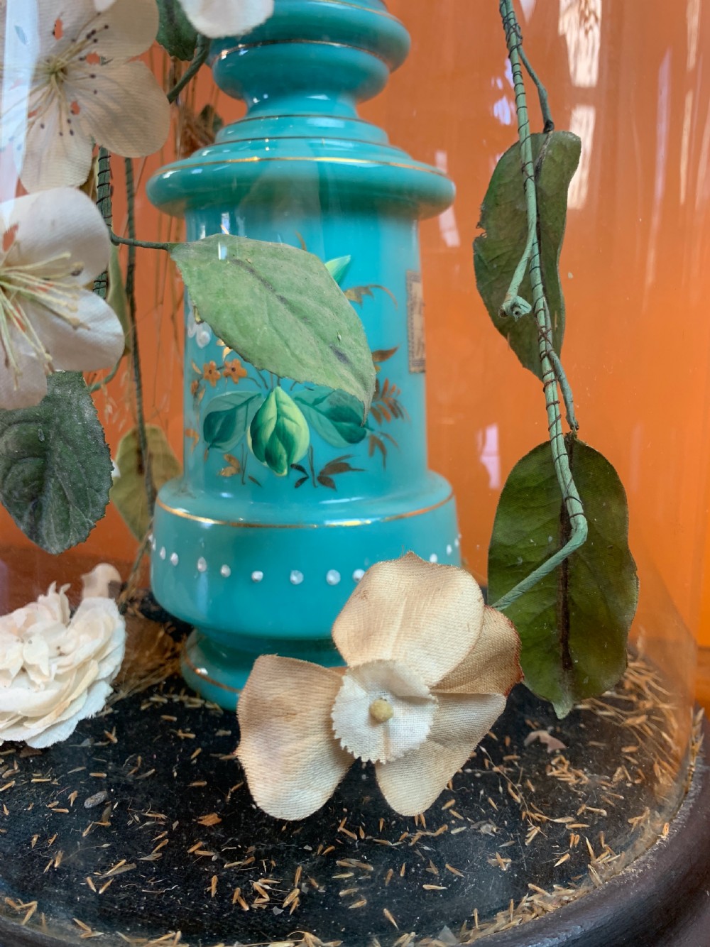 A tall Victorian glass dome containing a glass vase of faux flowers View II
