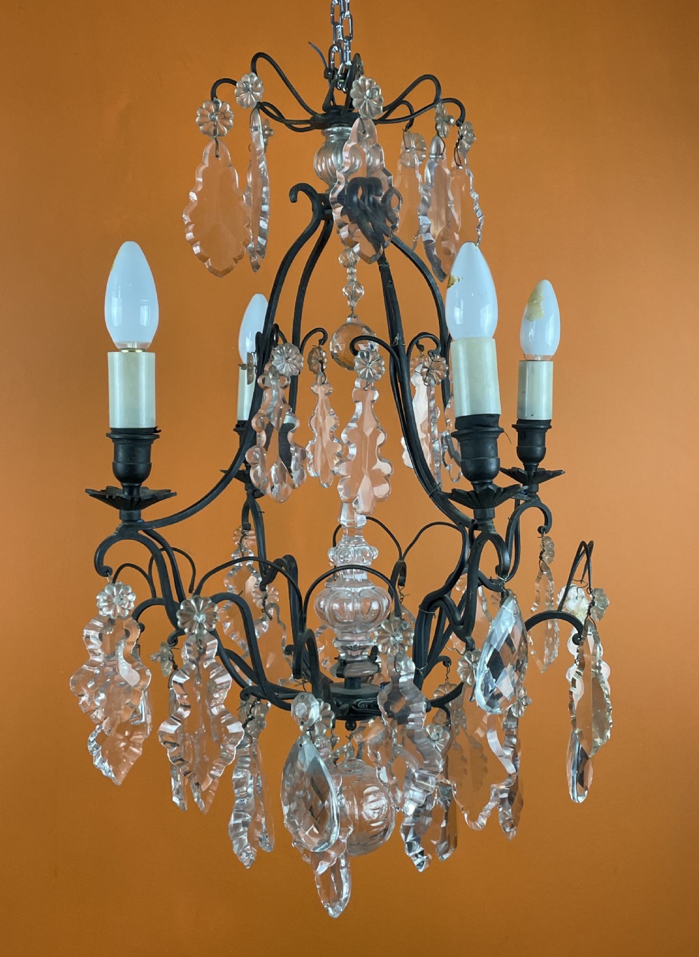 A French style cut glass cage chandelier featuring a dark wrought iron frame decorated with clear glass drops, rosettes, and candle-style bulb sockets. View III