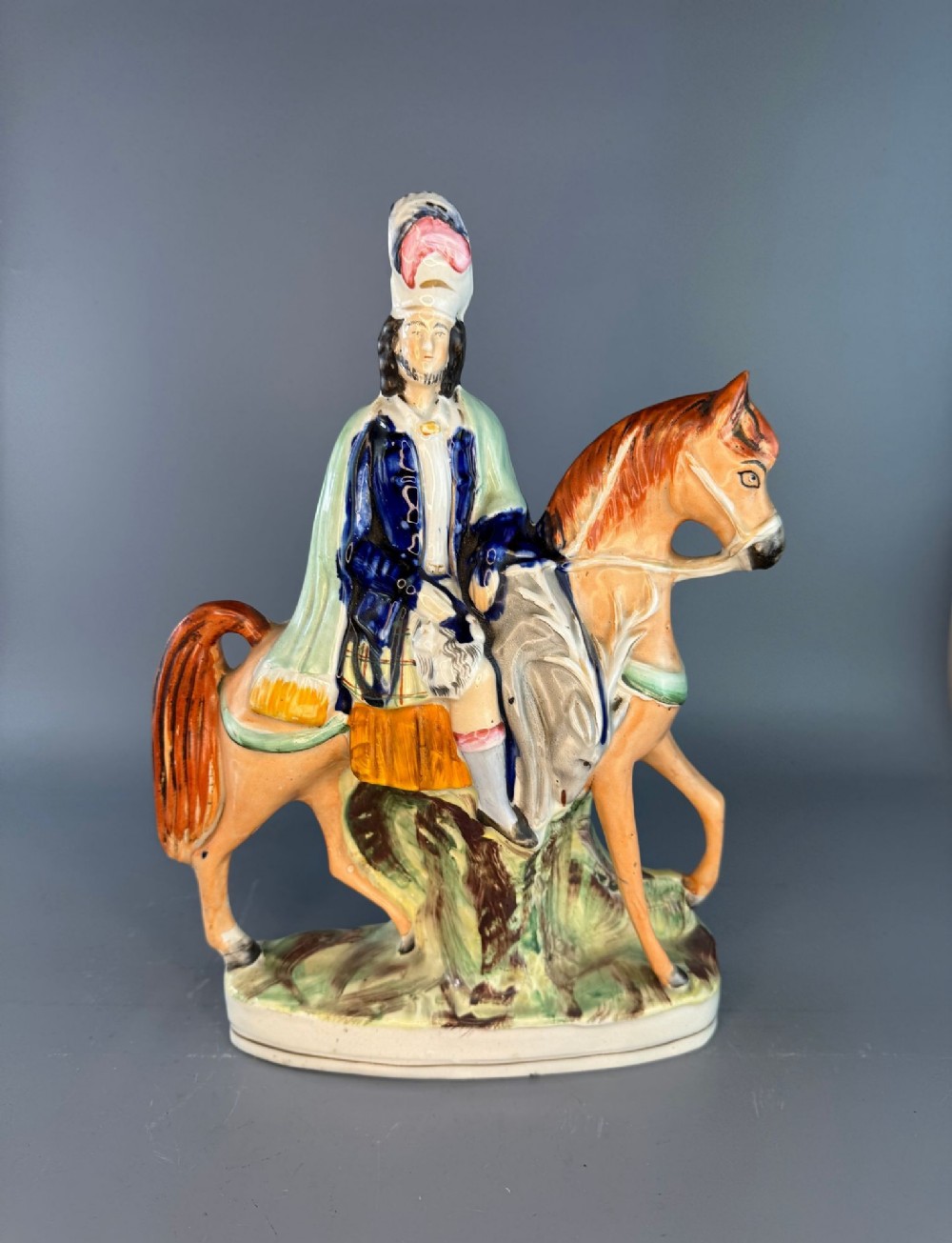 A Victorian Staffordshire earthenware flatback figure depicting a Scottish highlander mounted on a chestnut horse with hand-painted polychrome decoration.
