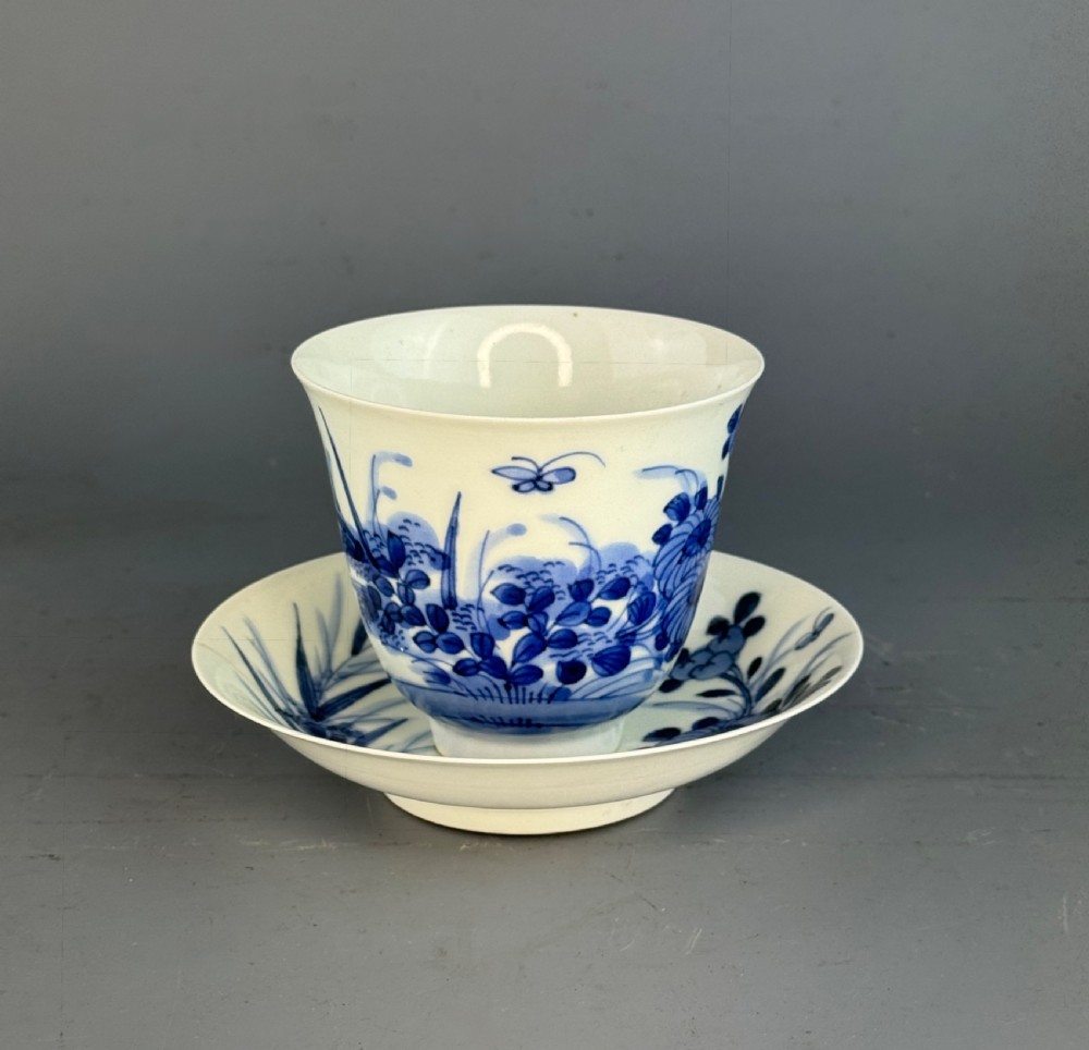 A 19th-century Japanese Hirado porcelain wine cup and matching saucer with cobalt blue underglaze hand-painted botanical motifs.