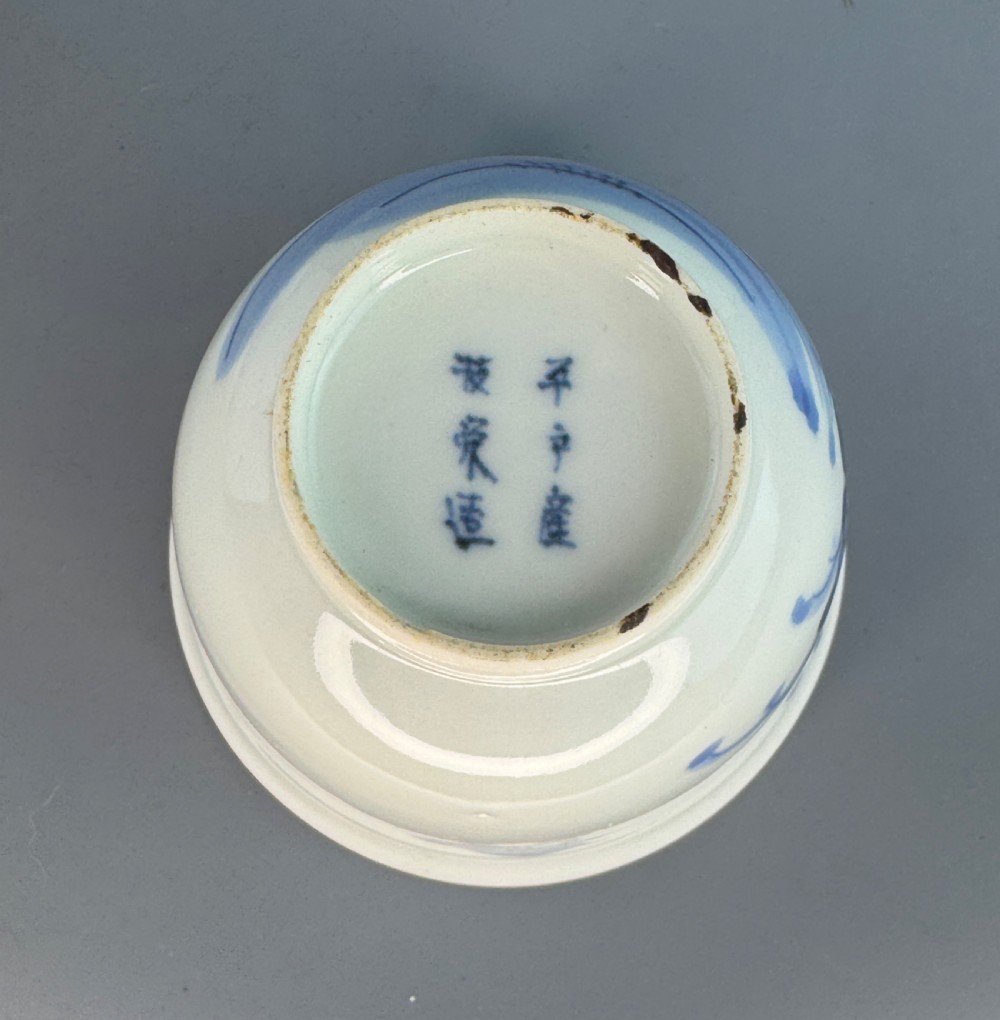 A 19th-century Japanese Hirado porcelain wine cup and matching saucer with cobalt blue underglaze hand-painted botanical motifs. View V