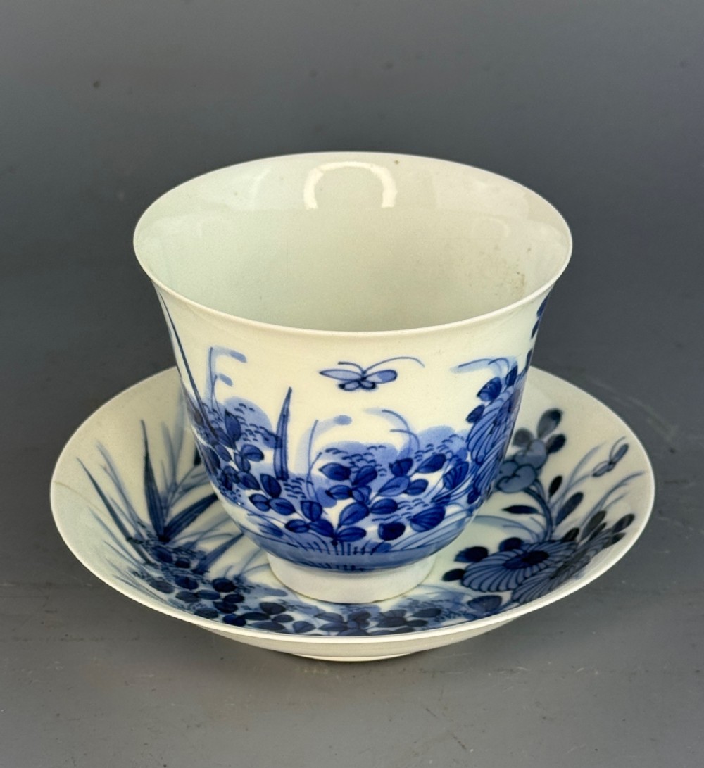 A 19th-century Japanese Hirado porcelain wine cup and matching saucer with cobalt blue underglaze hand-painted botanical motifs. View X