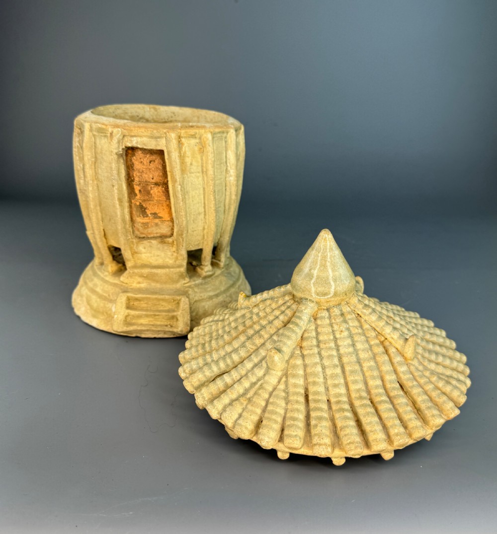 A pale celadon glazed ceramic granary model featuring a ribbed cylindrical body, rectangular doorway aperture, and a tiled pagoda roof topped with a pointed finial. View IV
