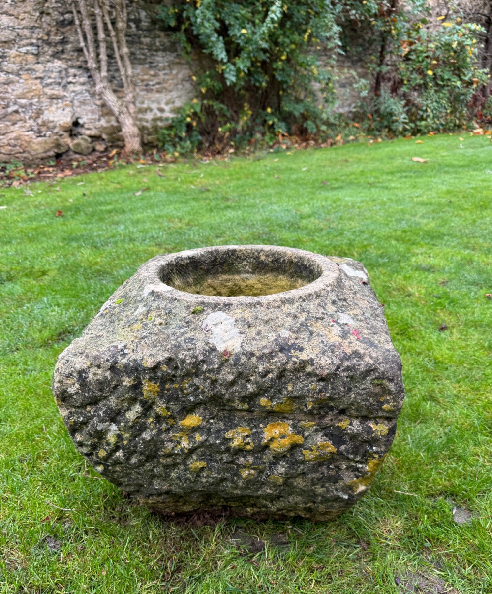 A square carved weathered stone planter with a circular central recess and rusticated hand-chiselled exterior surfaces displaying natural moss growth. View VII