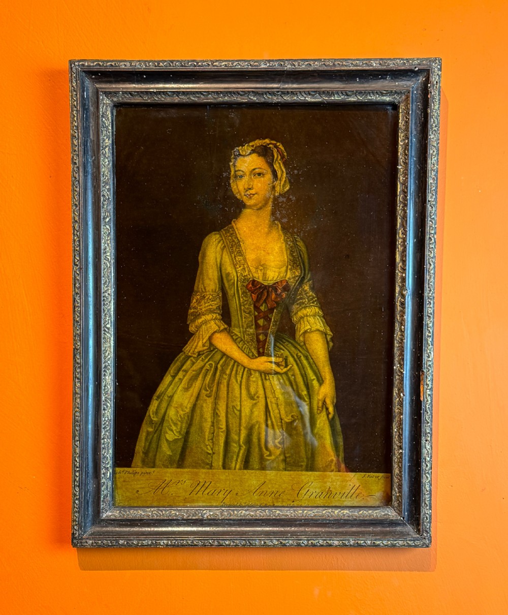 An 18th-century reverse glass mezzotint portrait depicting a woman in a yellow dress set within a dark moulded frame. View III