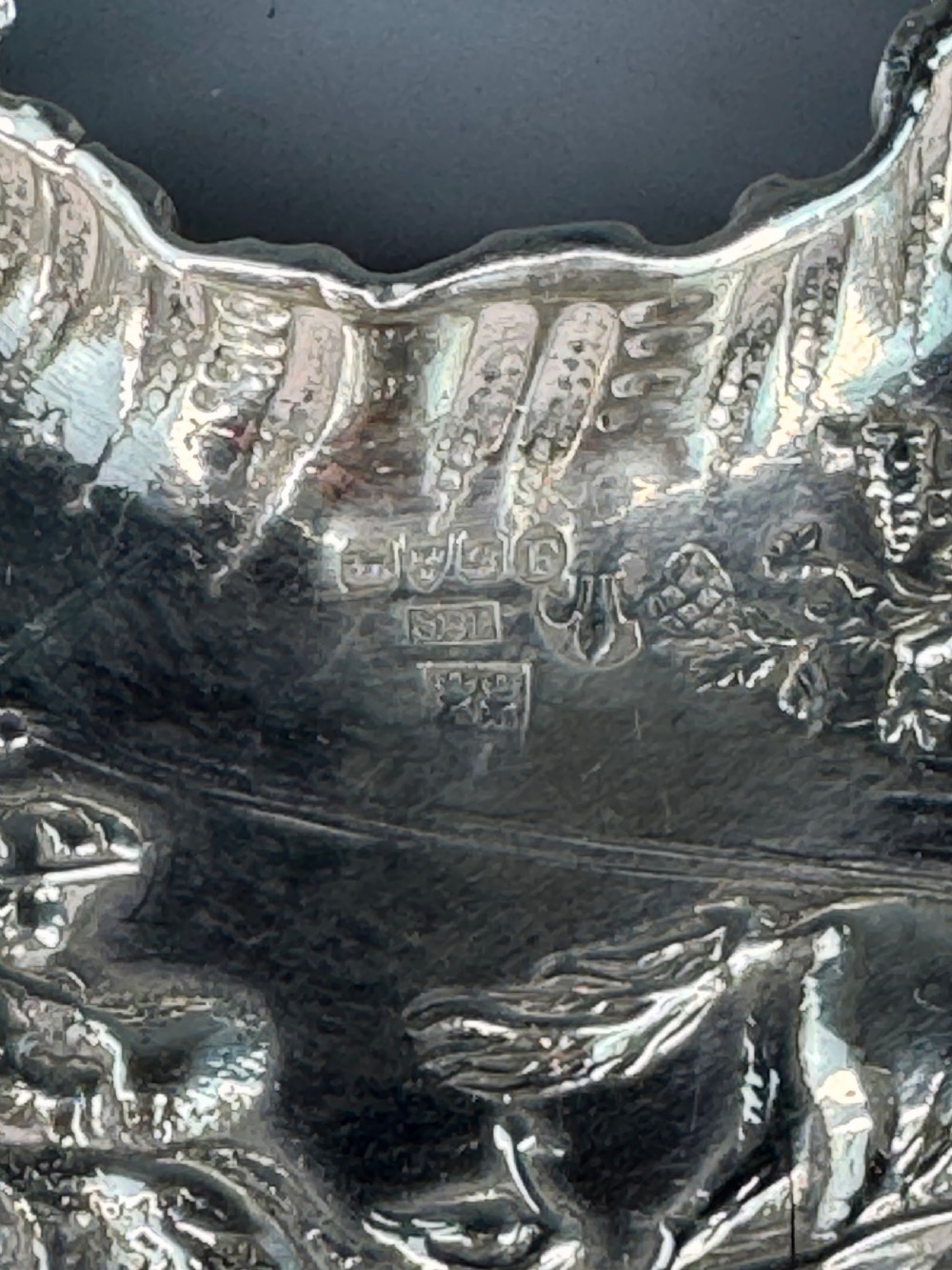 A late Victorian crescent-shaped sterling silver trinket dish with embossed repousse figural scenes and a fluted border. View III