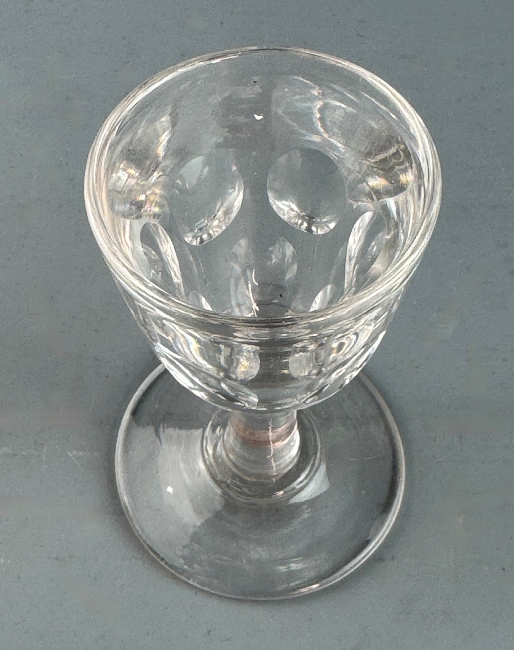A clear Victorian deception glass featuring a thick-walled thumb-cut bowl, short stem, and circular foot. View II
