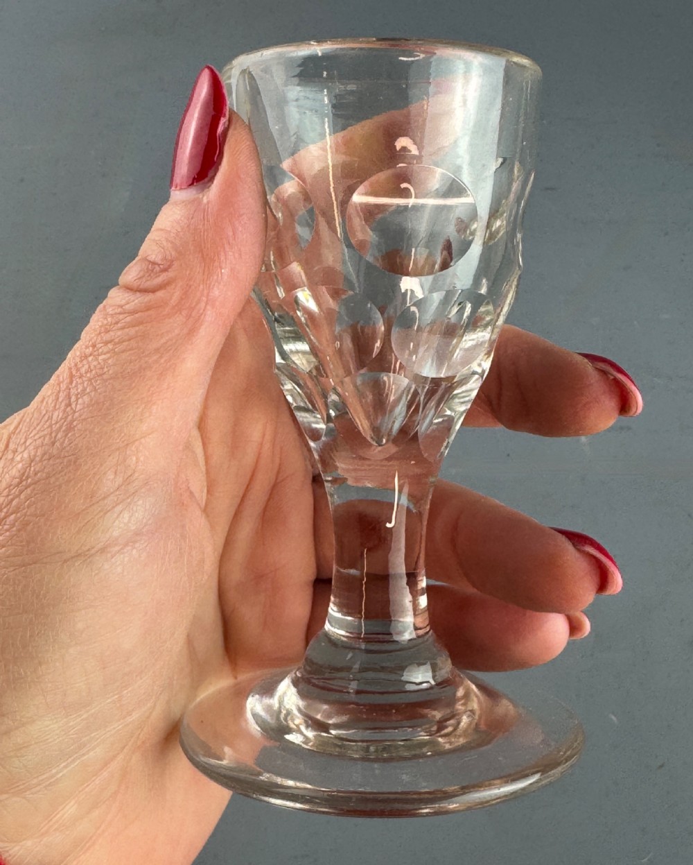 A clear Victorian glass featuring thumb-cut facets around the lower bowl, a short solid stem, and a wide flat base. View III