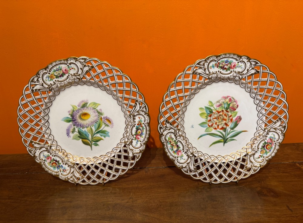 Pair of circular white porcelain plates with reticulated basketweave borders, gilded scrollwork, and hand-painted central botanical sprays. View II