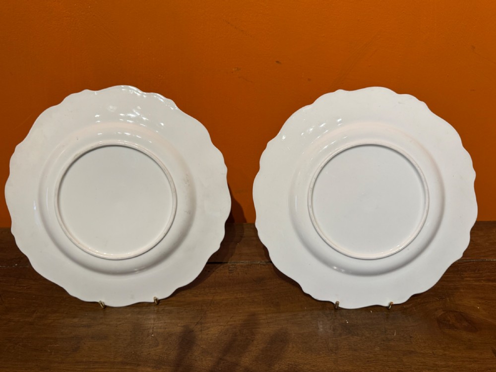 A pair of Victorian Coalport porcelain dessert plates featuring scalloped gilded rims, grey borders with gold foliage, and central hand-painted floral bouquets. View III