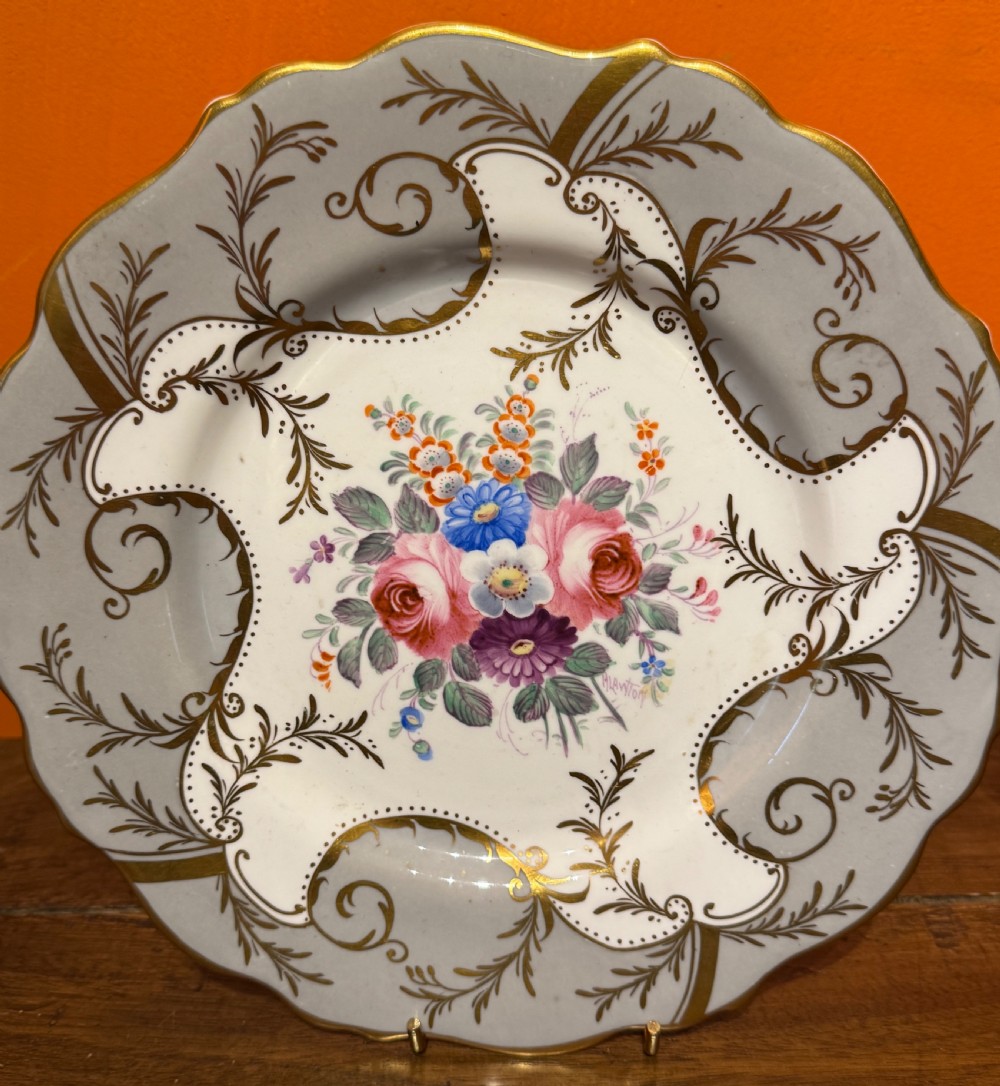 A pair of Victorian Coalport porcelain dessert plates featuring scalloped gilded rims, grey borders with gold foliage, and central hand-painted floral bouquets. View V