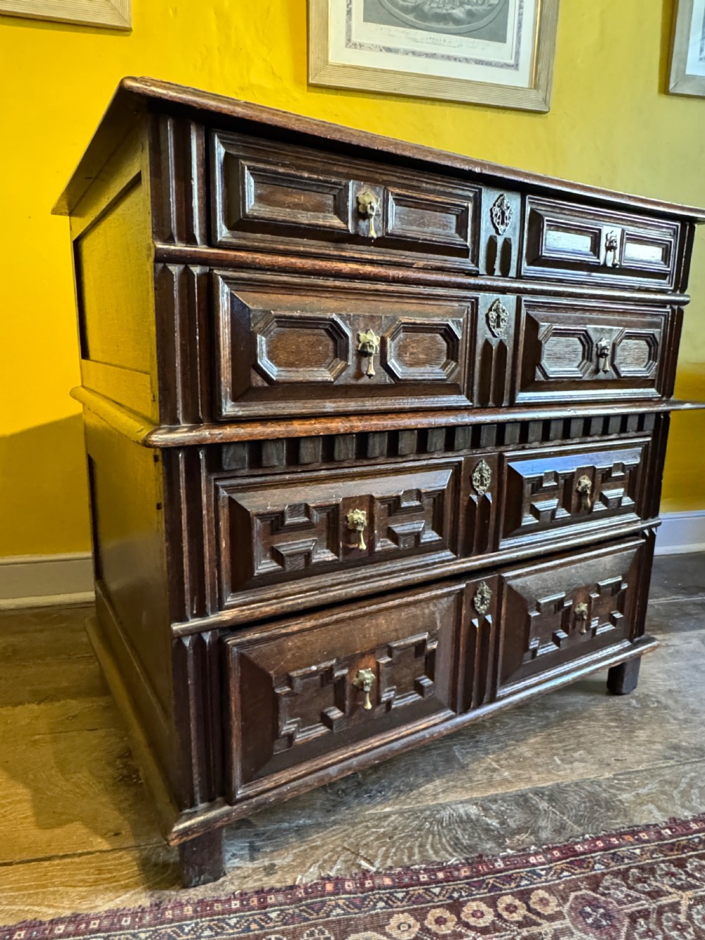 A 17th-century Charles II dark oak two-part chest of drawers featuring geometric mitred drawer mouldings and brass teardrop handles. View III