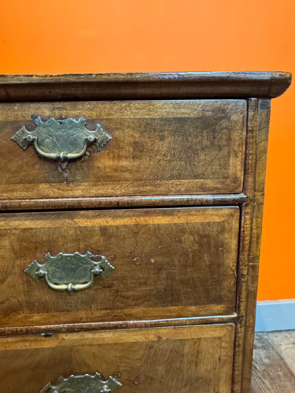 A George I walnut chest of drawers with two short over three long feather-banded drawers and brass handles. View VIII