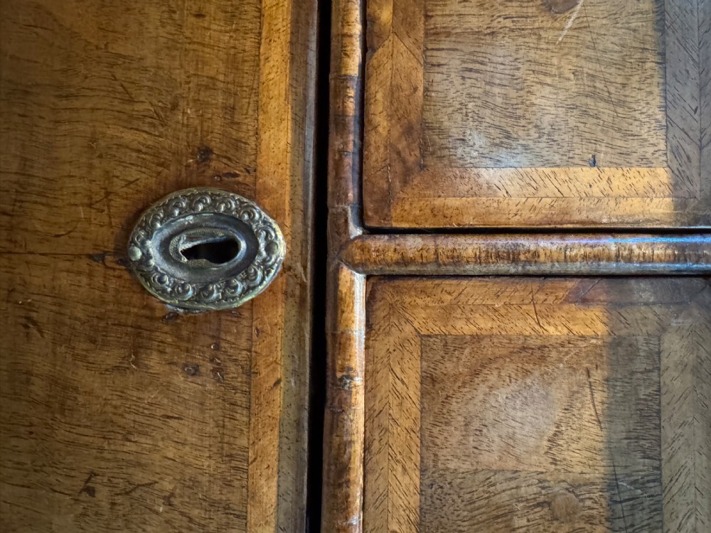 A George I walnut chest of drawers with two short over three long feather-banded drawers and brass handles. View X
