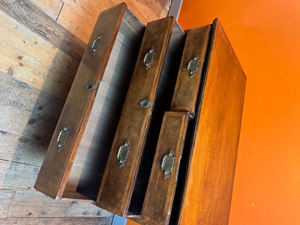 A George I walnut chest of drawers with two short over three long feather-banded drawers and brass handles. View XII