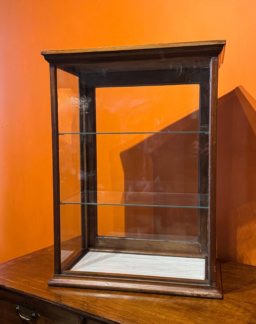 An Edwardian tabletop display cabinet featuring a mahogany frame with clear glass panels on all sides and two interior glass shelves. View II