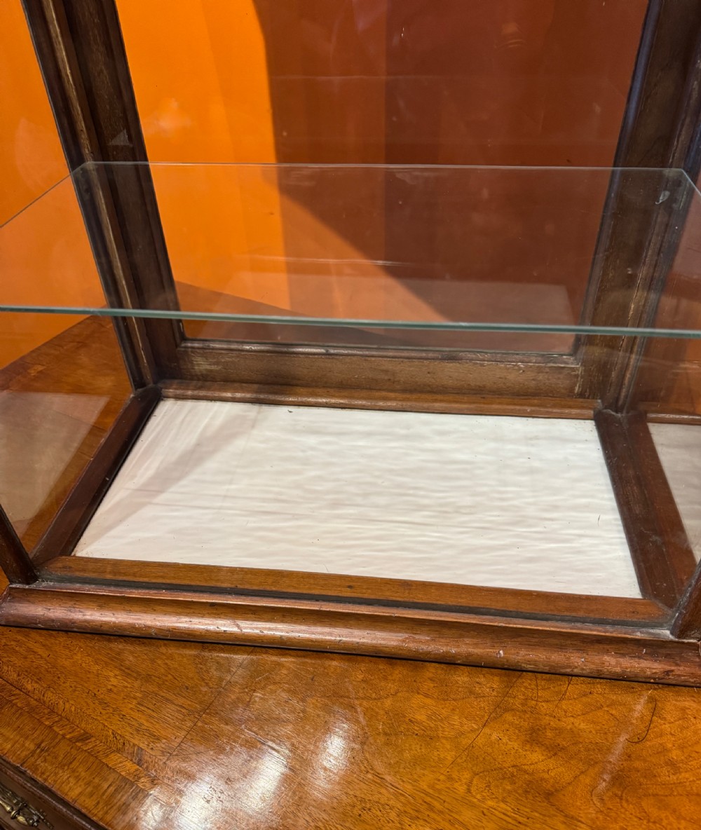 An Edwardian tabletop display cabinet featuring a mahogany frame with clear glass panels on all sides and two interior glass shelves. View III