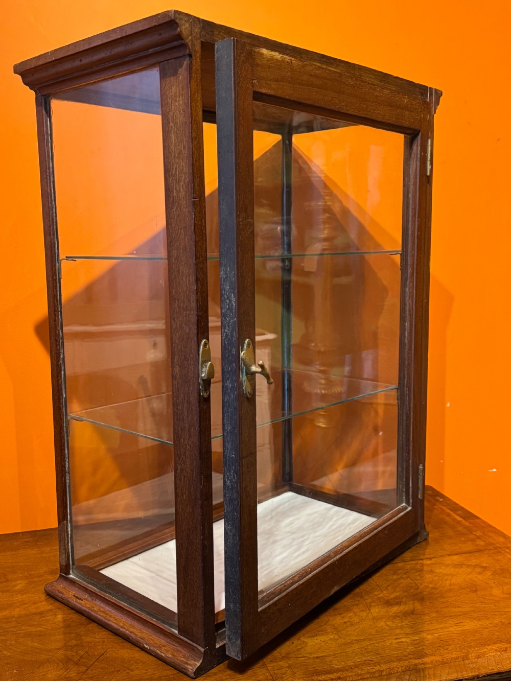 An Edwardian tabletop display cabinet featuring a mahogany frame with clear glass panels on all sides and two interior glass shelves. View IV