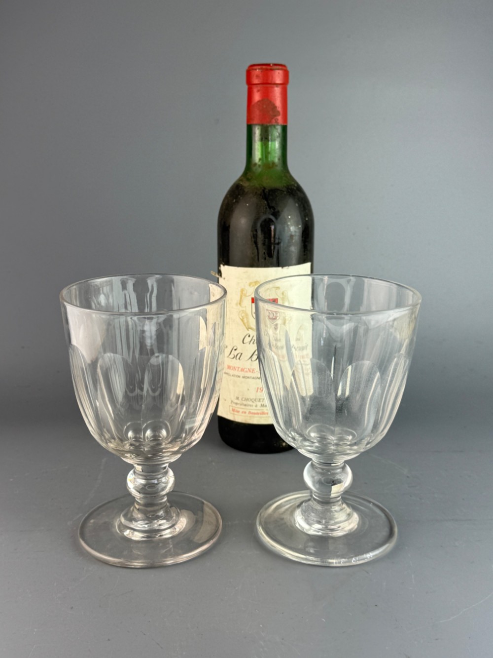A pair of clear cut glass rummers with fluted lower bowls, short knopped stems, and broad circular bases. View II