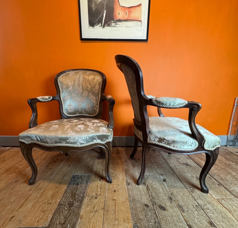 A pair of Louis XV style walnut fauteuil armchairs upholstered in sage green floral silk damask fabric featuring carved cabriole legs. View II