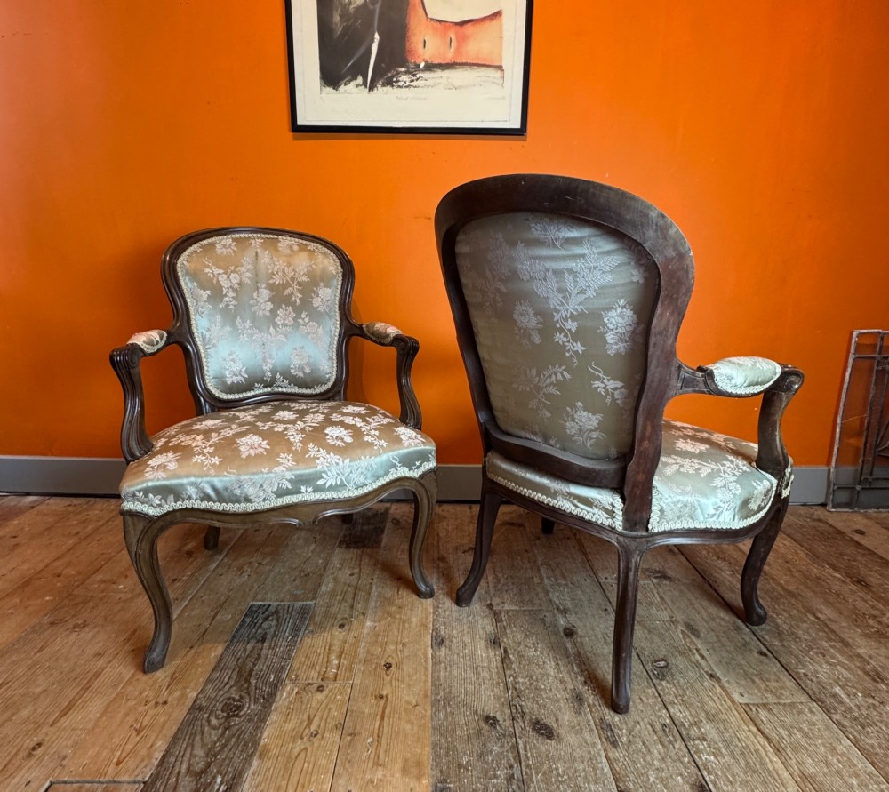 A pair of Louis XV style walnut fauteuil armchairs upholstered in sage green floral silk damask fabric featuring carved cabriole legs. View V