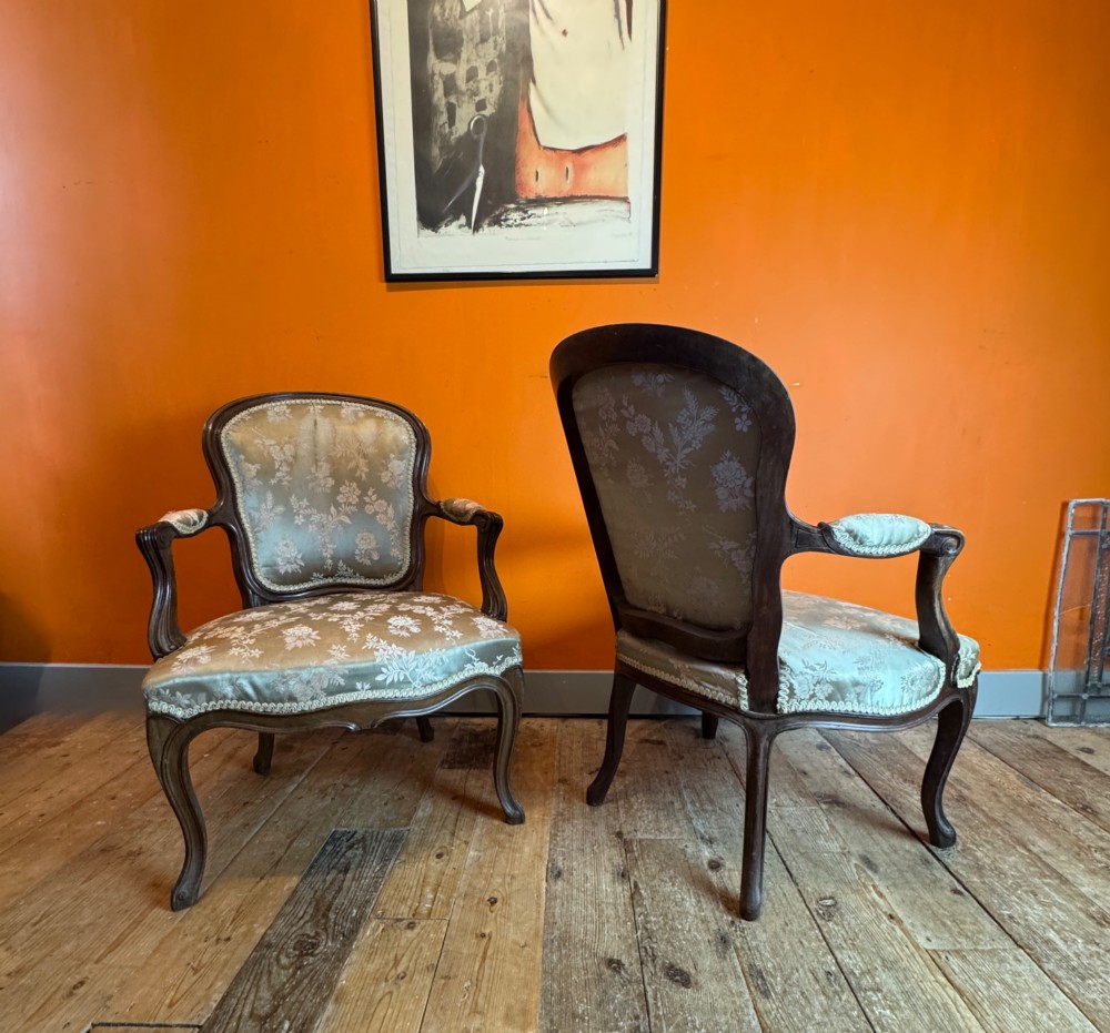 A pair of Louis XV style walnut fauteuil armchairs upholstered in sage green floral silk damask fabric featuring carved cabriole legs. View VI