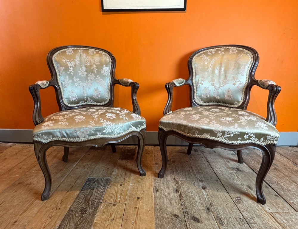 A pair of Louis XV style walnut fauteuil armchairs upholstered in sage green floral silk damask fabric featuring carved cabriole legs. View VII