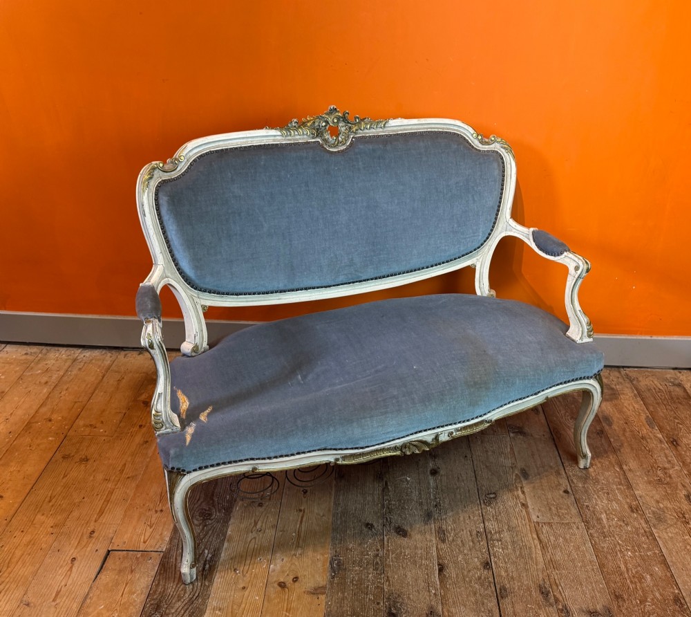 An antique Louis XV style two-seat settee featuring a cream painted and carved wooden frame with gilt accents, cabriole legs, and blue-grey fabric upholstery. View VII