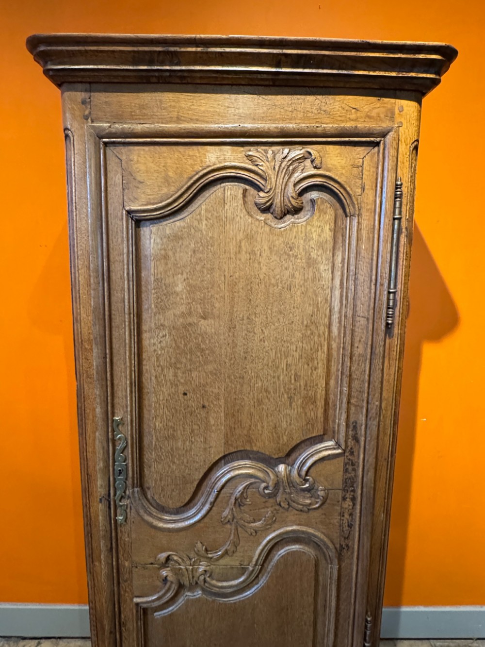 A 19th-century French oak bonnetiere featuring a single door with Louis XV style carved foliate mouldings, long iron hinges, and cabriole feet. View V