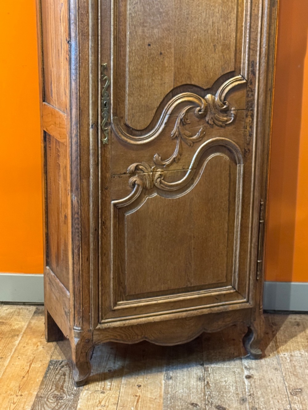 A 19th-century French oak bonnetiere featuring a single door with Louis XV style carved foliate mouldings, long iron hinges, and cabriole feet. View VI