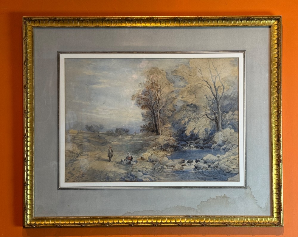 Framed landscape watercolour depicting figures beside a river with trees, presented in a cloth mount and a molded gilt frame. View II