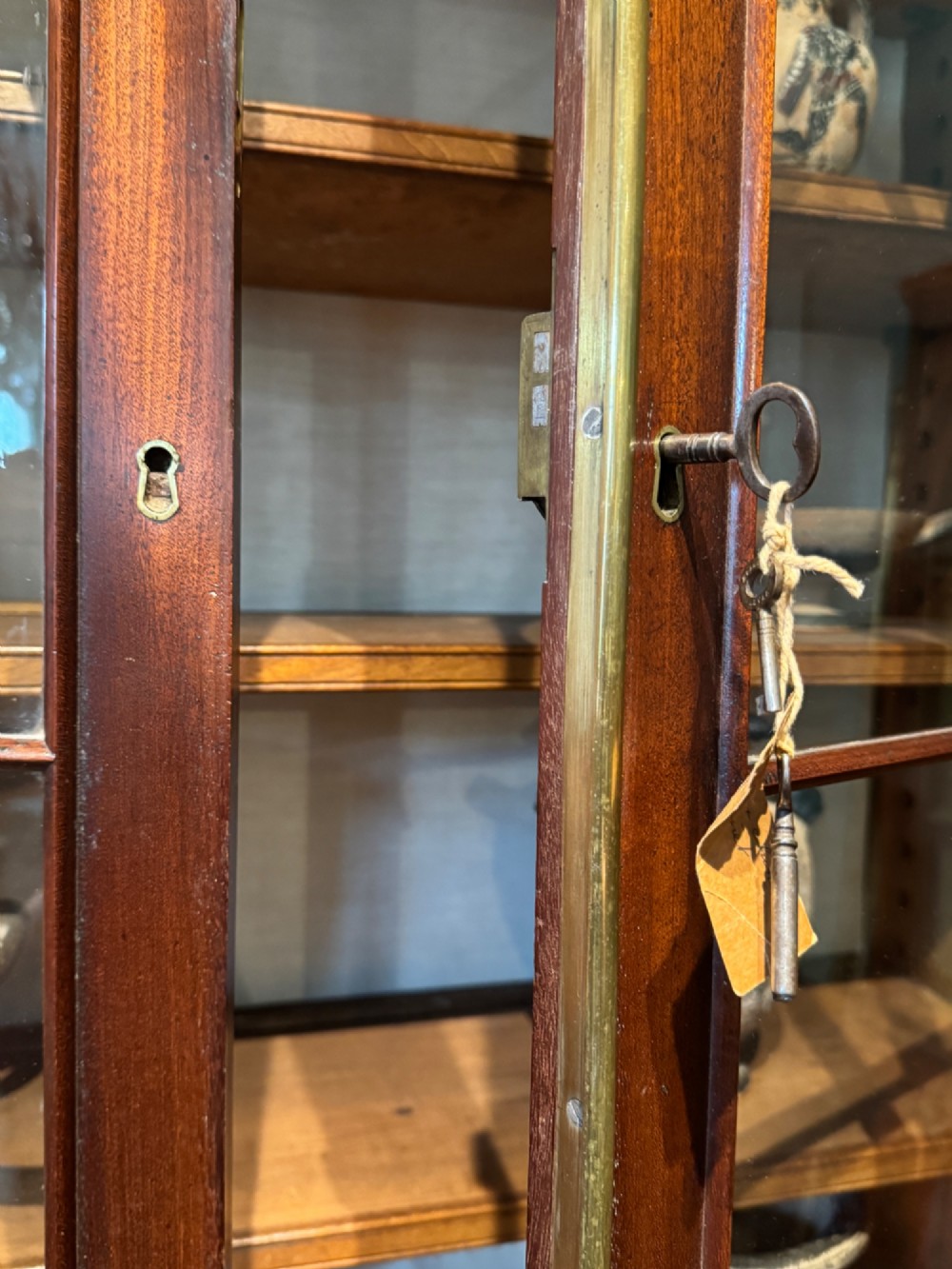 An antique Regency mahogany secretaire bookcase featuring upper Gothic astragal glazed doors over a lower chest of drawers on turned feet. View VII