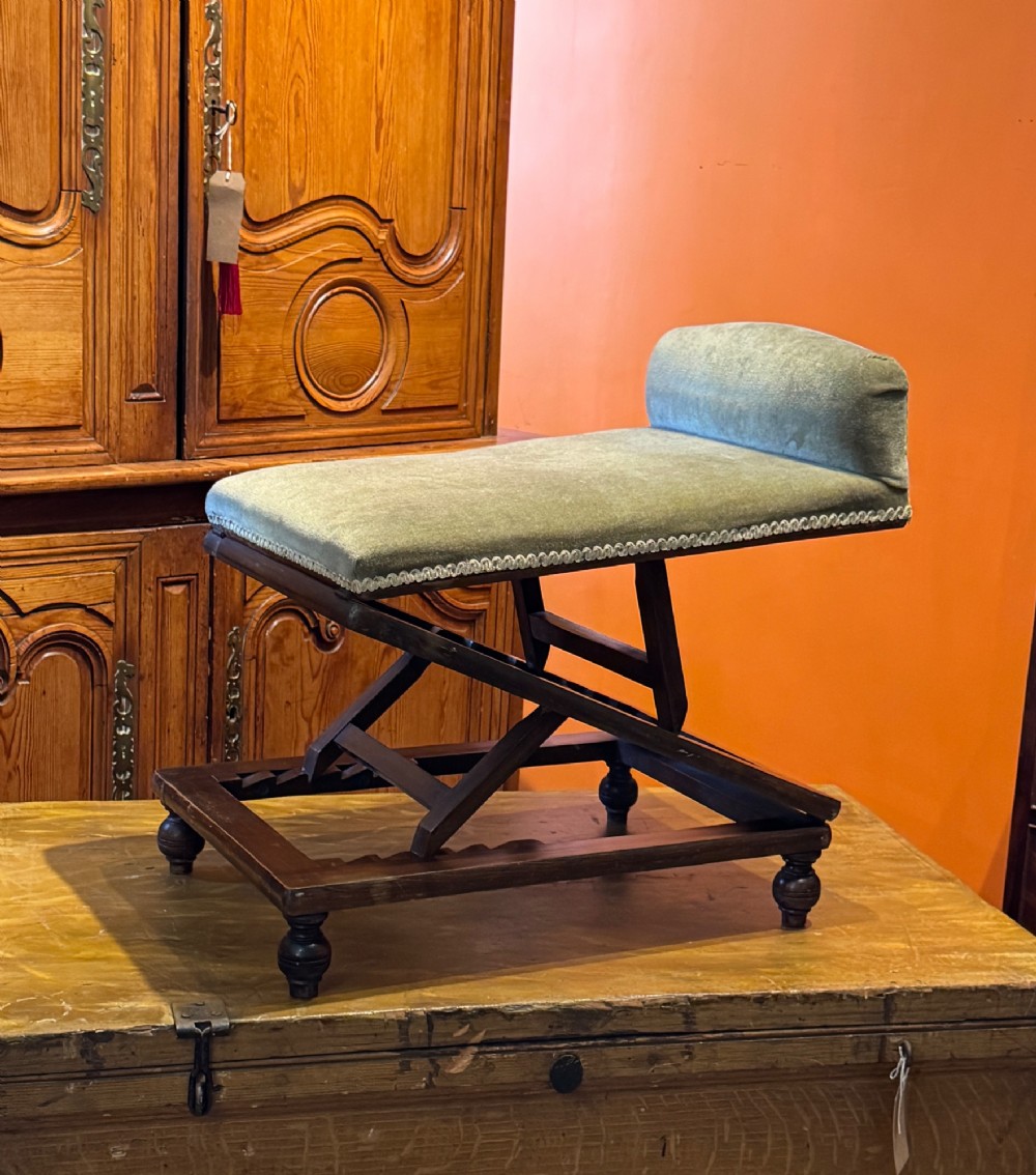 An antique Victorian metamorphic gout stool with a dark stained beech ratchet frame and an inclined green velvet upholstered cushion. View III