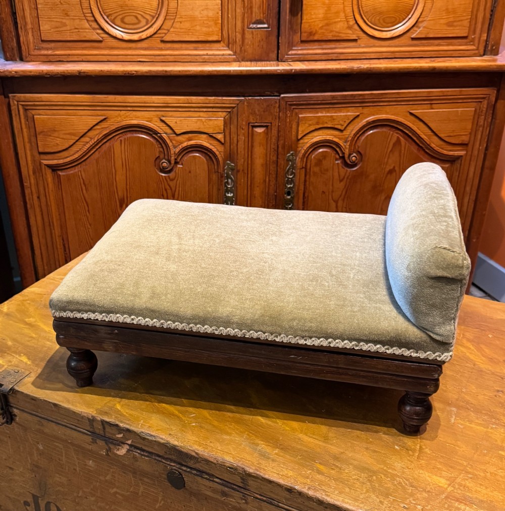An antique Victorian metamorphic gout stool with a dark stained beech ratchet frame and an inclined green velvet upholstered cushion. View IV