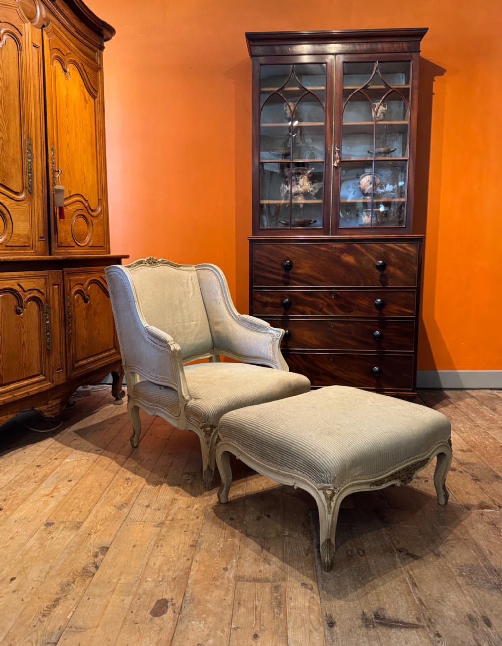 A French Louis XV style duchesse brisee comprising a painted armchair and matching footstool with cabriole legs and neutral upholstery.
