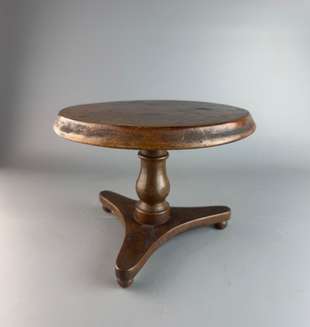 A Victorian turned mahogany treen candlestand crafted in the form of a miniature circular tripod tilt-top table.