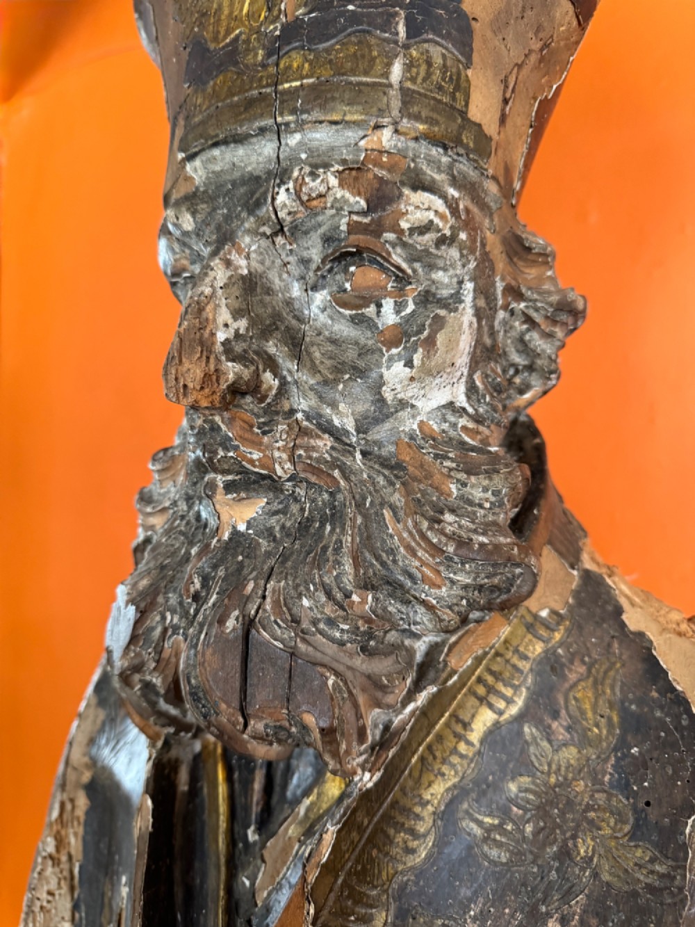 An eighteenth-century carved gilt-wood bust of a bearded bishop wearing a mitre, showing distressed gilding and mounted on a dark wooden block base. View VI
