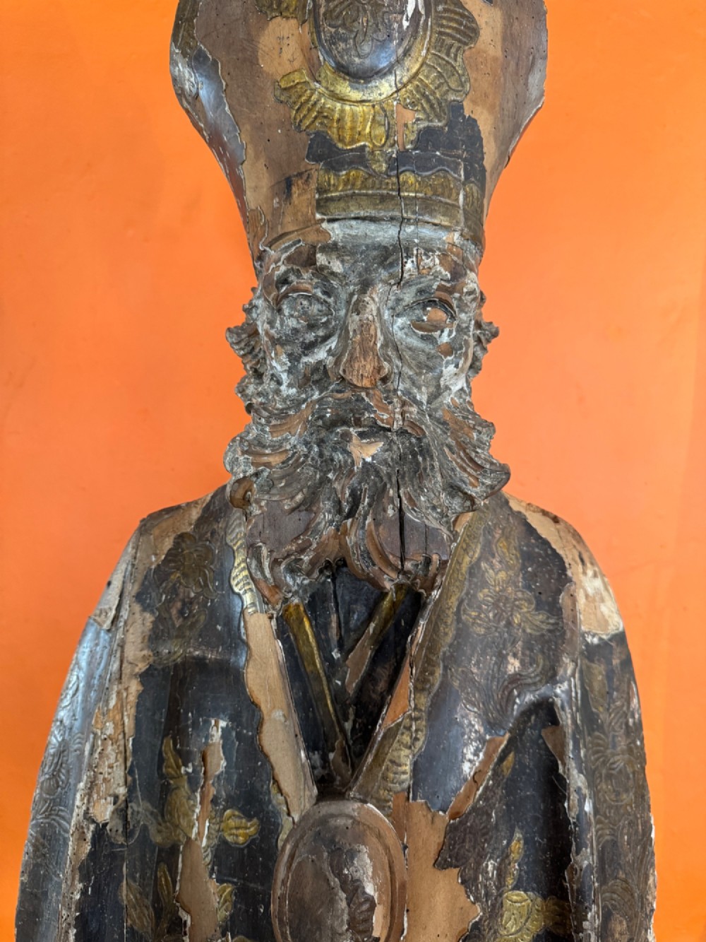 An eighteenth-century carved gilt-wood bust of a bearded bishop wearing a mitre, showing distressed gilding and mounted on a dark wooden block base. View VIII